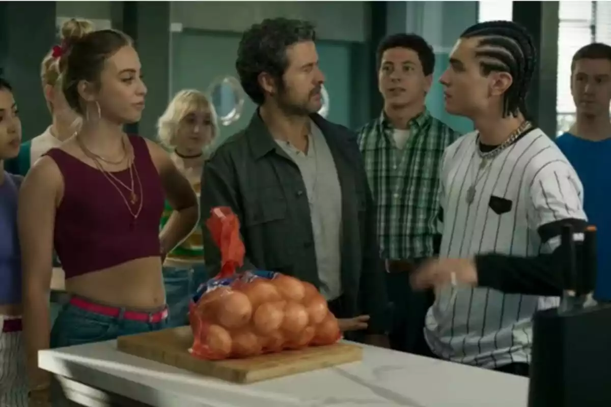 Un grupo de personas encabezado por Diego Martín está reunido en una cocina alrededor de una mesa donde hay una bolsa de cebollas en la serie Sin Gluten. Un grupo de personas encabezado por Diego Martín está reunido en una cocina alrededor de una mesa donde hay una bolsa de cebollas en la serie Sin Gluten.