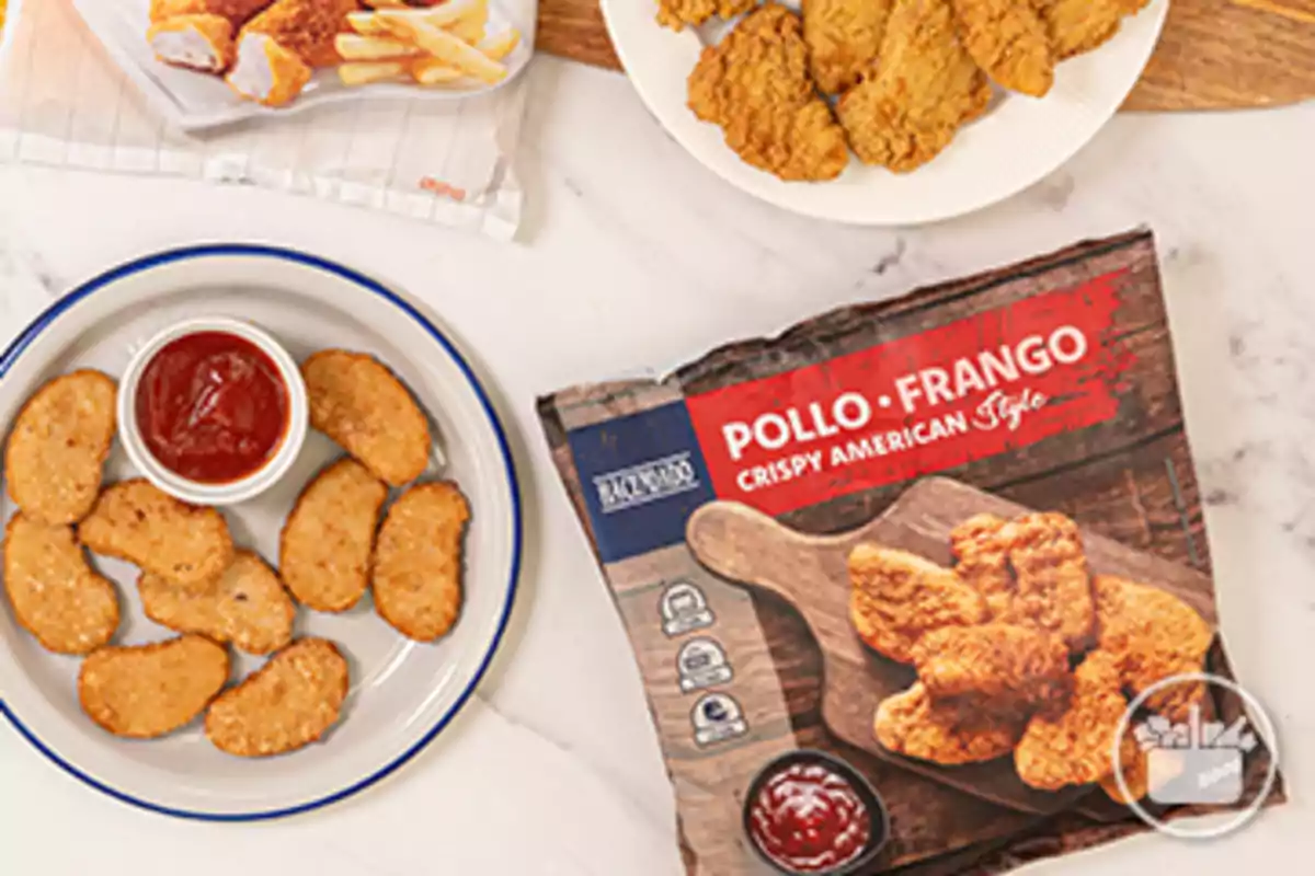 Paquet de pollastre arrebossat estil americà al costat d’un plat amb nuggets i salsa de tomàquet Paquet de pollastre arrebossat estil americà al costat d’un plat amb nuggets i salsa de tomàquet