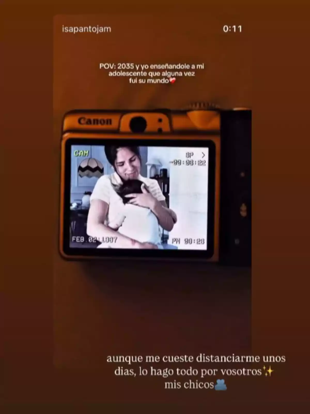 Una cámara Canon muestra en su pantalla la imagen de Isa Pantoja abrazando a su niño, acompañada de un texto emotivo sobre la maternidad y el paso del tiempo.