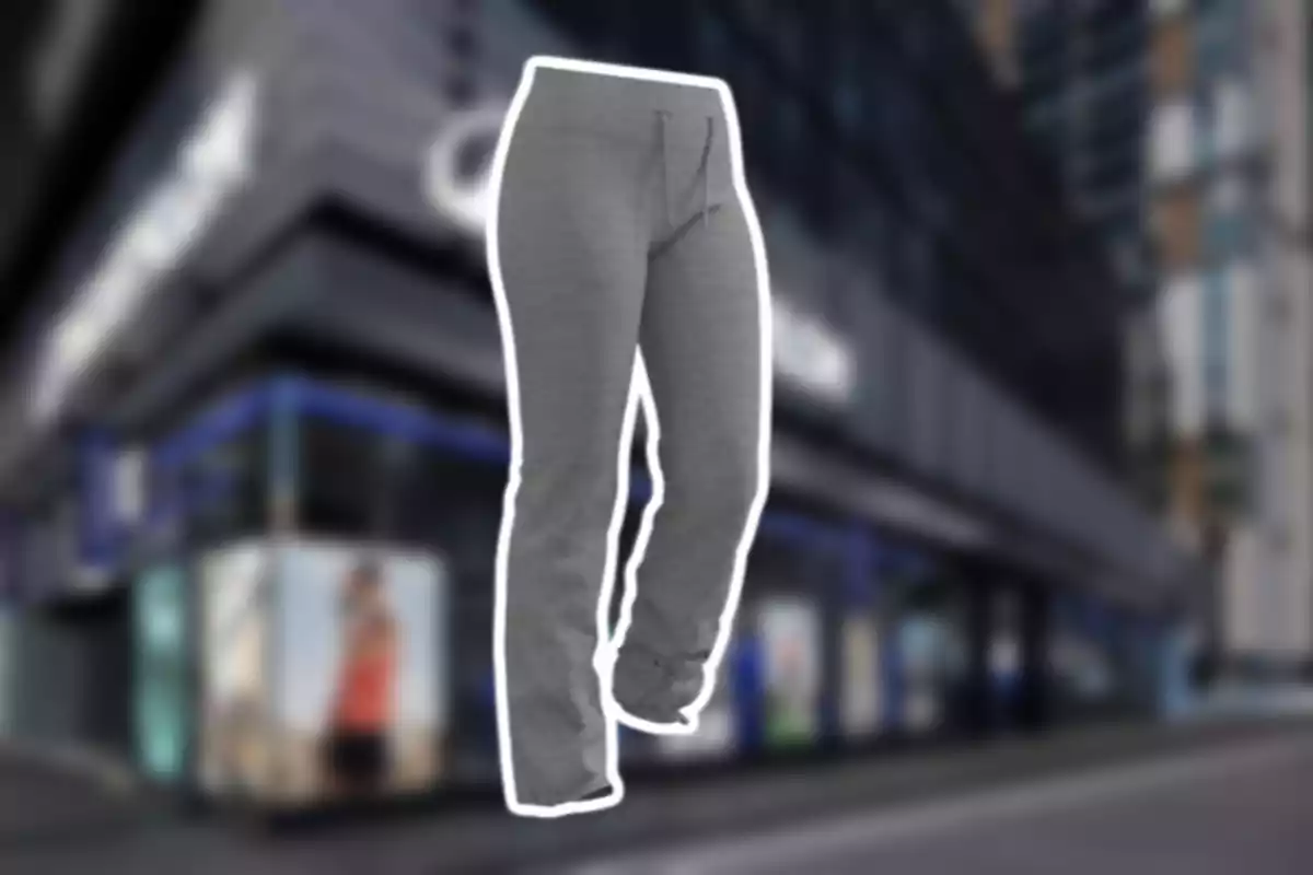 Pantaló esportiu gris amb cordó ajustable sobre un fons de botiga desenfocat