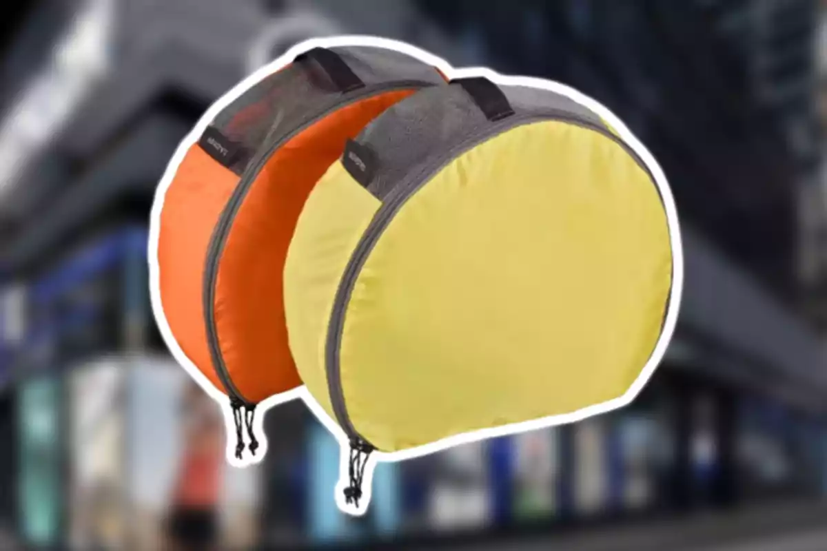 Dues bosses rodones de tela, una groga i una taronja, amb tancament i detalls en gris, sobre un fons desenfocat. Dues bosses rodones de tela, una groga i una taronja, amb tancament i detalls en gris, sobre un fons desenfocat.