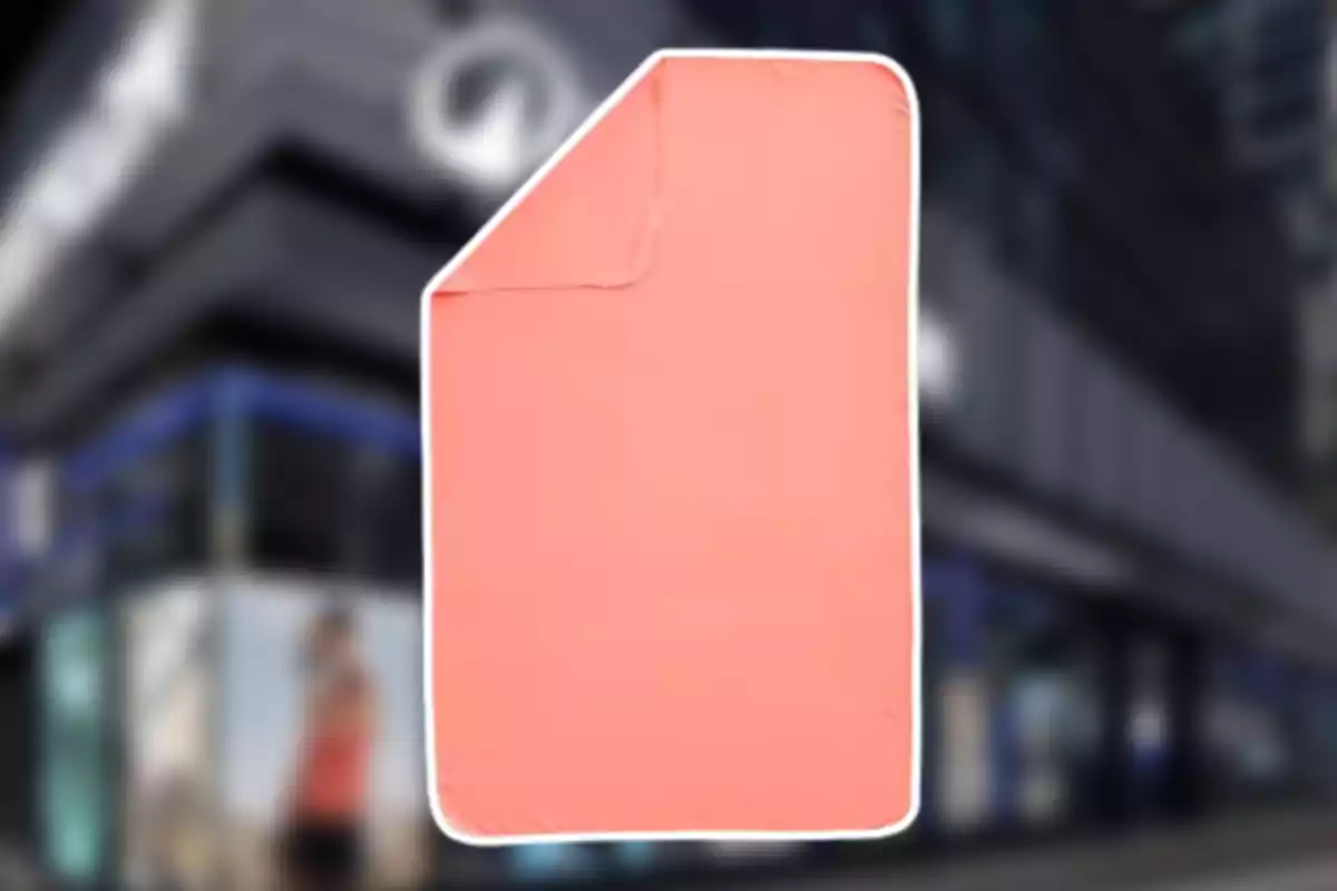 Manta de color salmó amb vora blanca sobre un fons urbà desenfocat