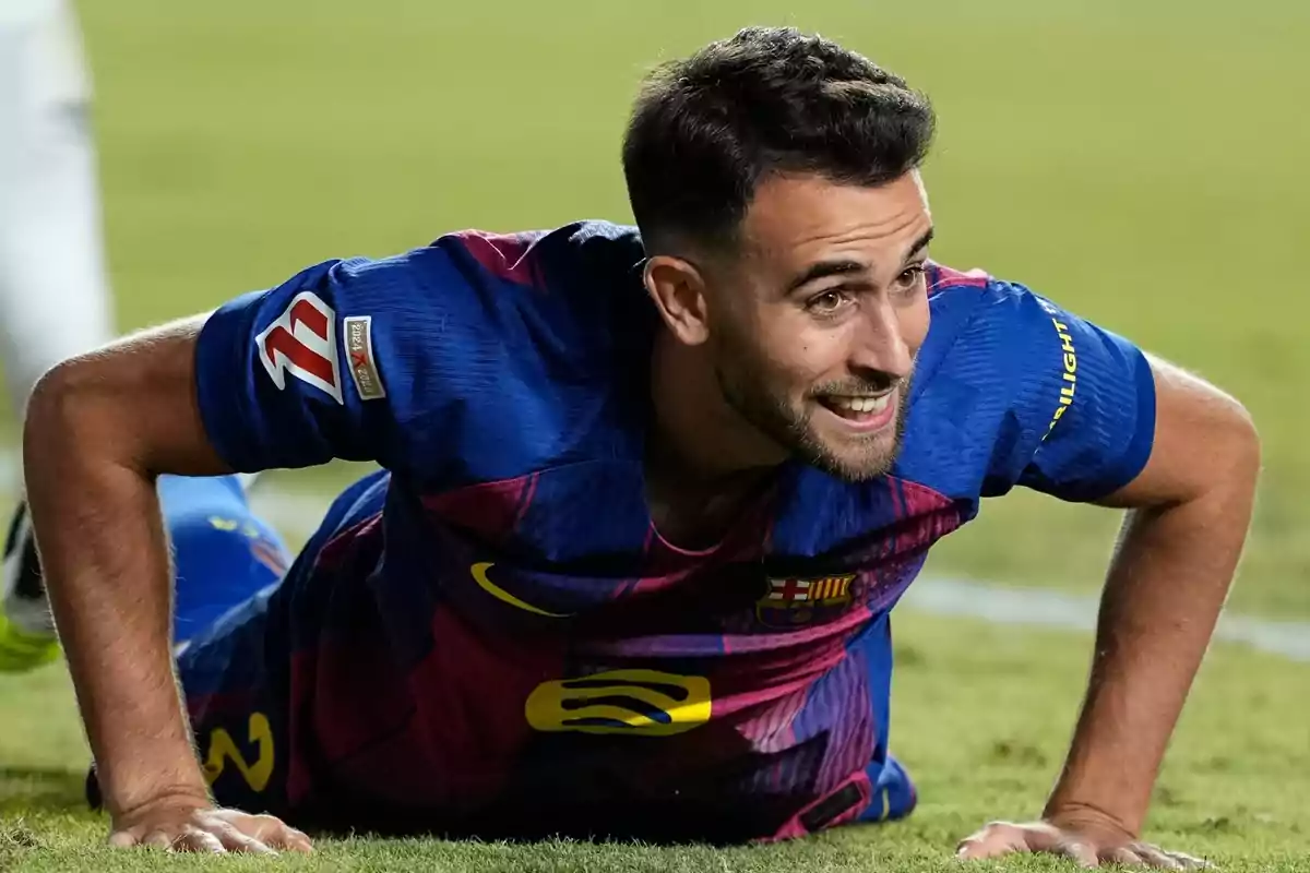 Futbolista con uniforme azul y rojo del Barcelona sonríe mientras está en el césped durante un partido Futbolista con uniforme azul y rojo del Barcelona sonríe mientras está en el césped durante un partido
