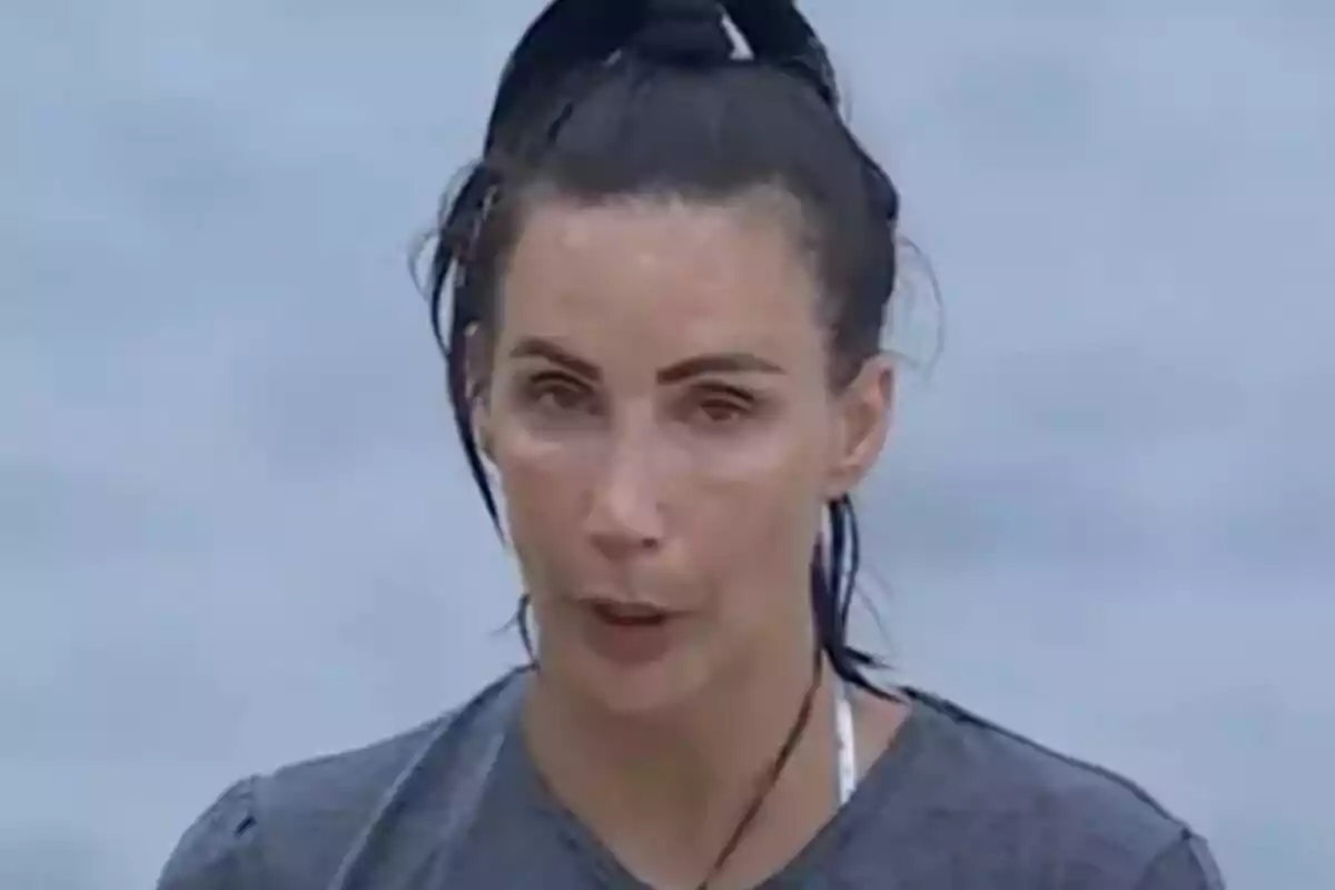 Fani Carbajo de cabell fosc recollit amb expressió seriosa i fons desenfocat blau clar de Supervivientes All Stars