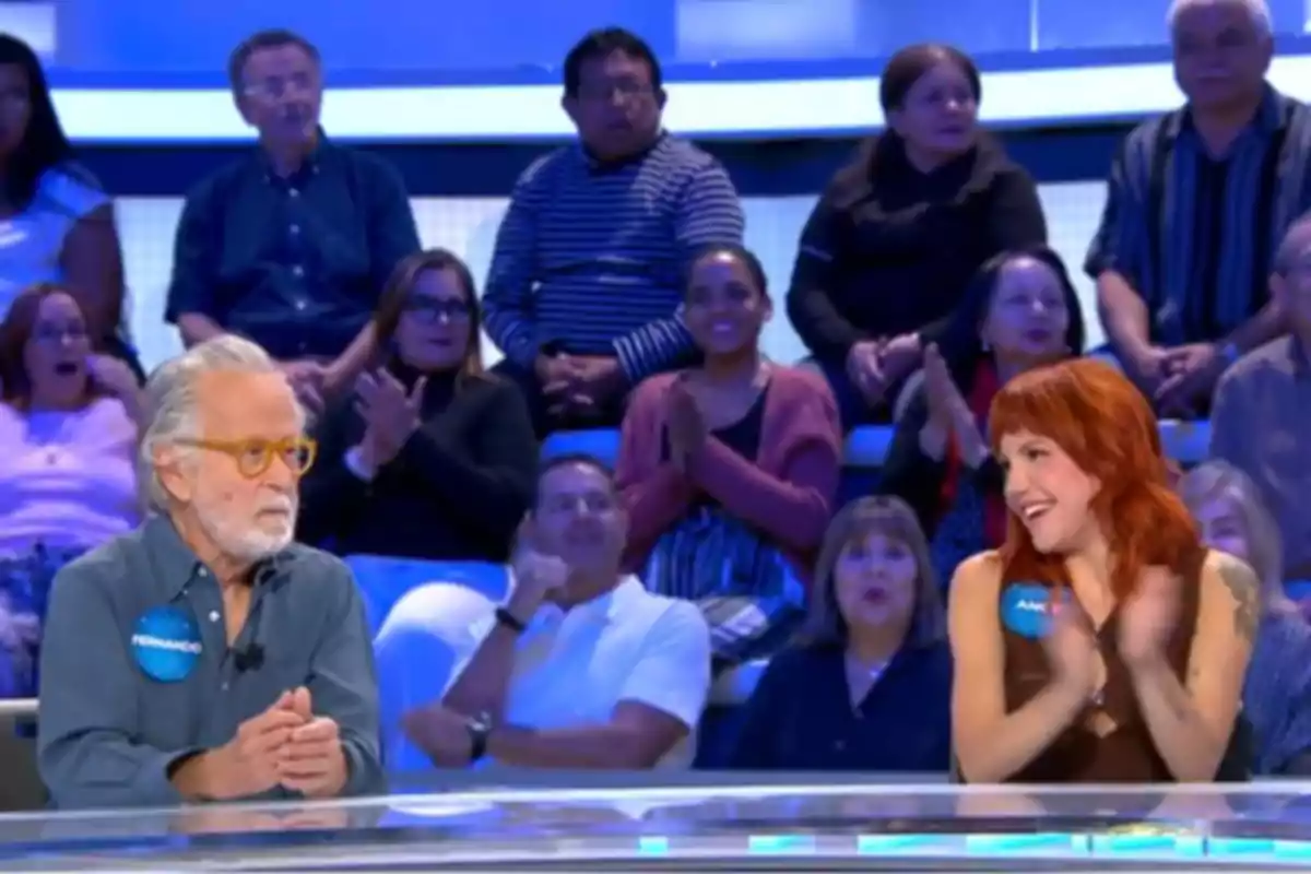 Angy i Fernando Colomo asseguts a 'Pasapalabra' amb públic aplaudint al fons Angy i Fernando Colomo asseguts a 'Pasapalabra' amb públic aplaudint al fons