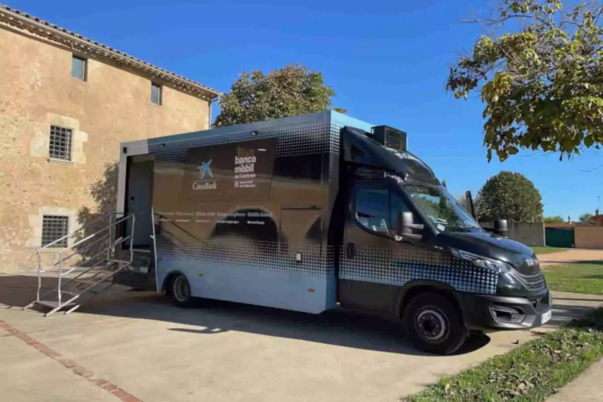 Camió de banca mòbil estacionat al costat d’un edifici de pedra en un dia assolellat Camió de banca mòbil estacionat al costat d’un edifici de pedra en un dia assolellat