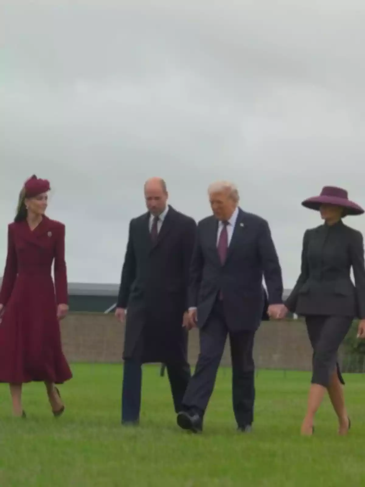Donald Trump, Melania Trump, Kate Middleton i el príncep Guillem elegantment vestits caminen sobre la gespa sota un cel ennuvolat.