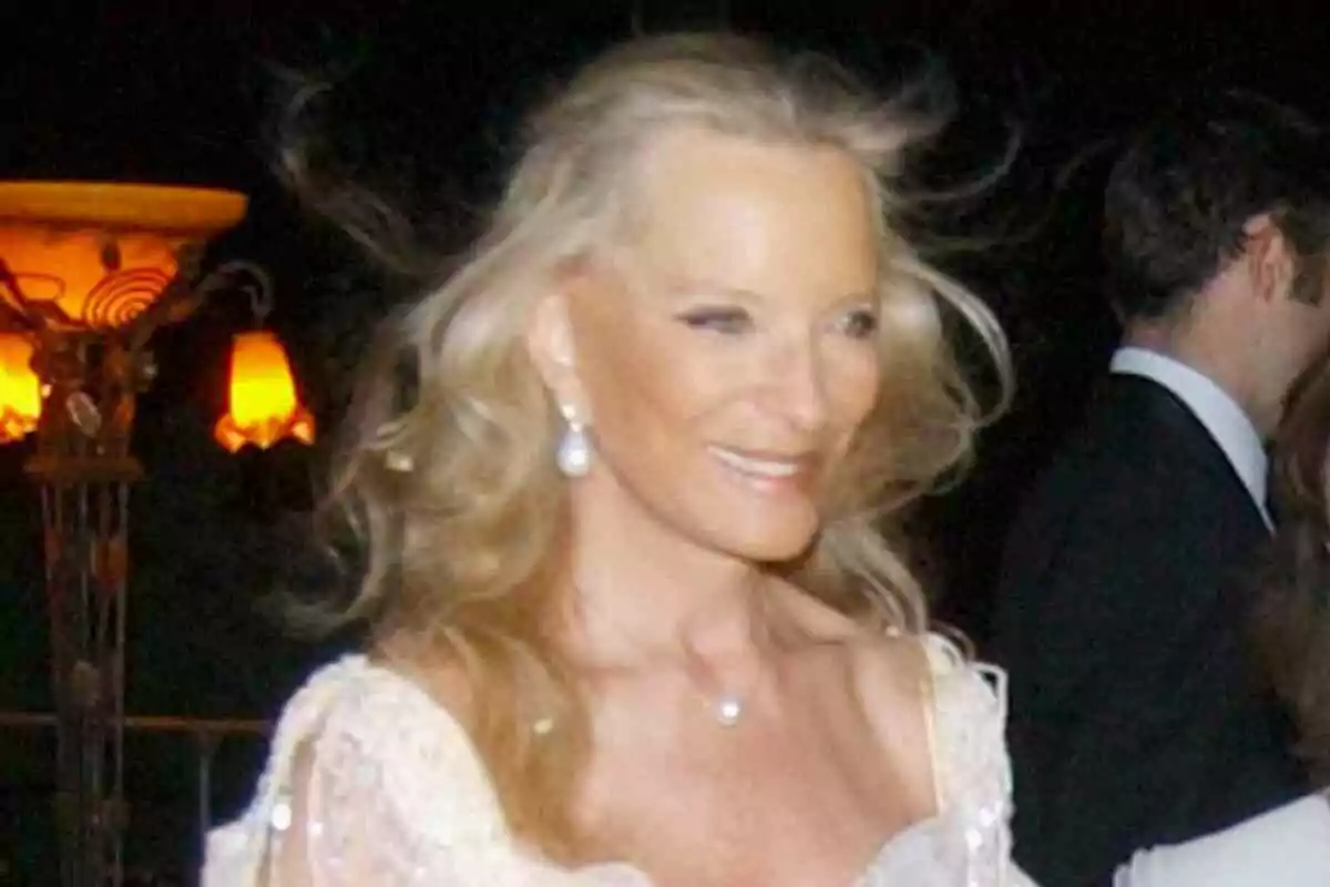 La duquesa de Kent amb vestit elegant i joies somriu en un esdeveniment nocturn amb llums càlides de fons