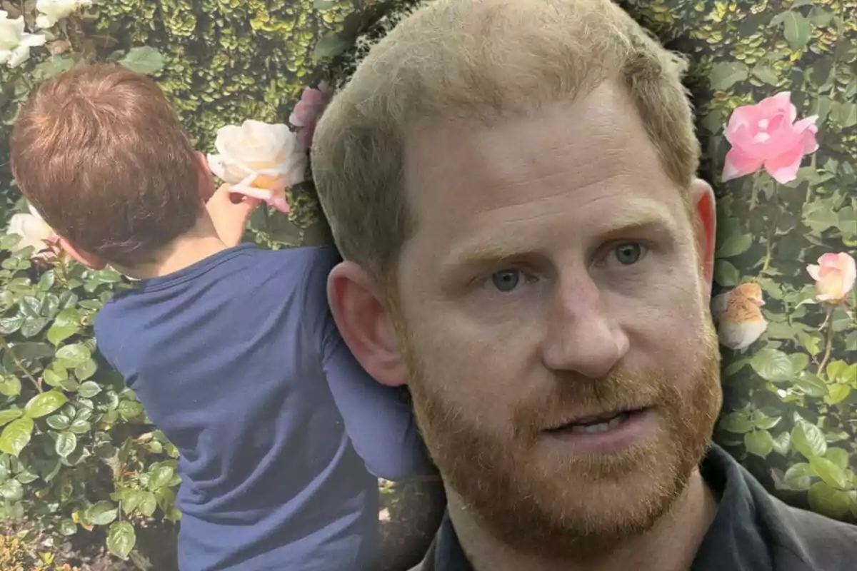 Un home pèl-roig amb barba en primer pla i un nen d’esquena tocant una rosa en un jardí ple de flors Un home pèl-roig amb barba en primer pla i un nen d’esquena tocant una rosa en un jardí ple de flors