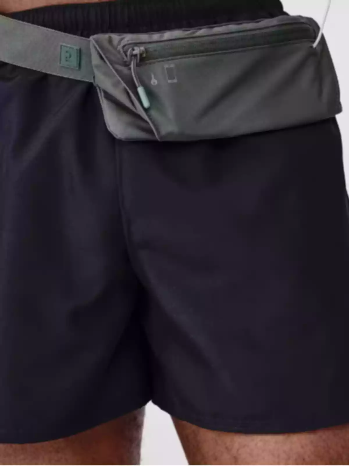 Persona amb una ronyonera grisa sobre pantalons foscos