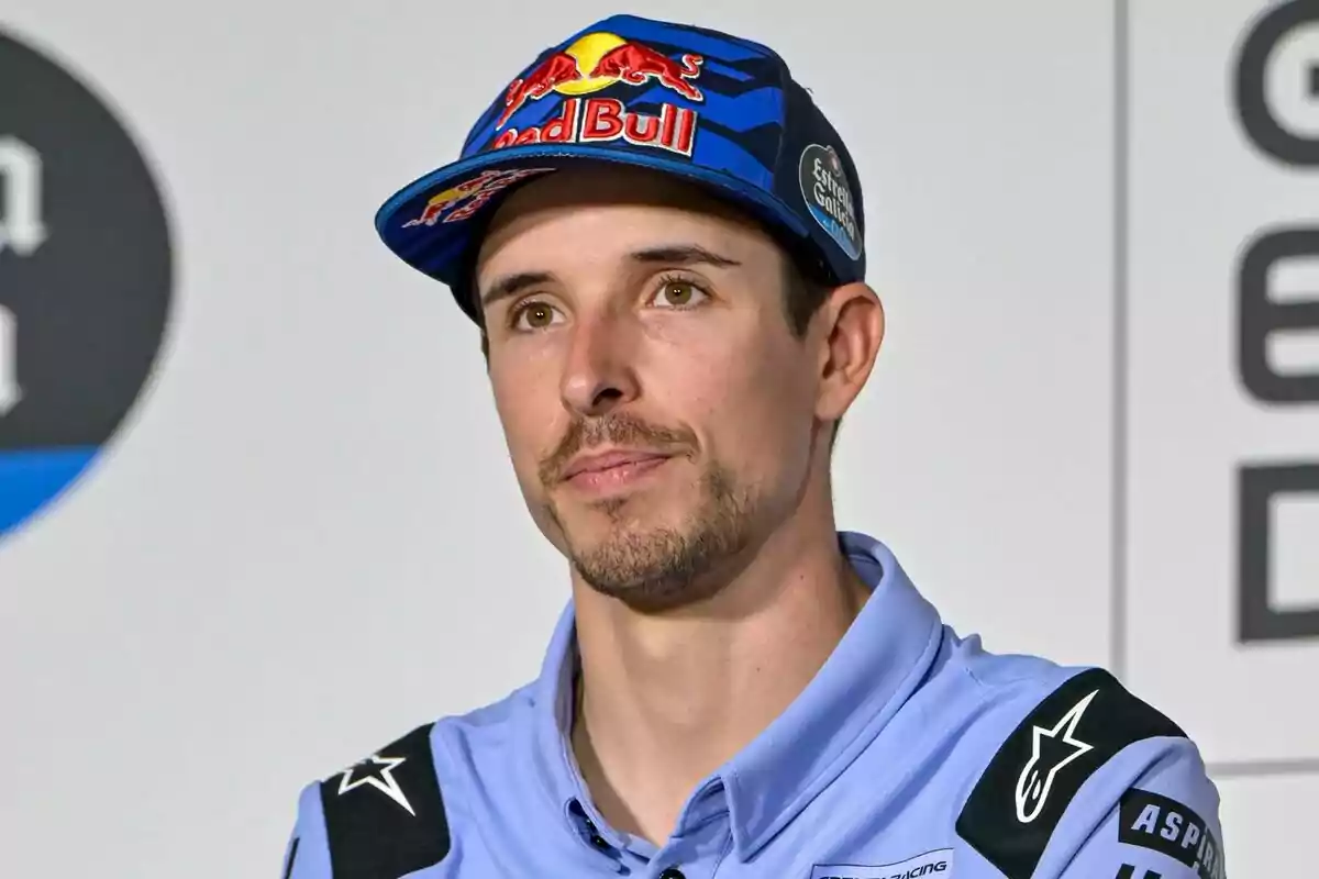 Home jove amb barba curta i bigoti, portant una gorra blava de Red Bull i una camisa blau clar, en un entorn interior amb fons clar i logotips. Home jove amb barba curta i bigoti, portant una gorra blava de Red Bull i una camisa blau clar, en un entorn interior amb fons clar i logotips.