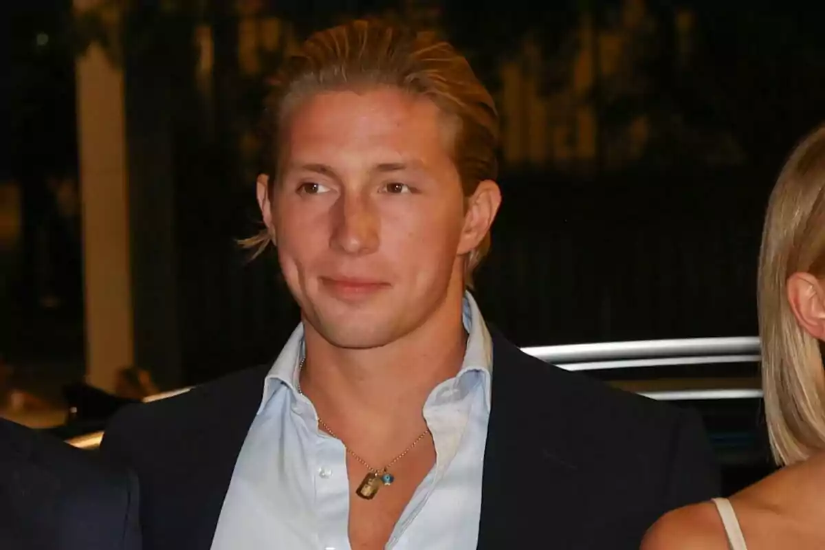 Jove de cabell ros pentinat cap enrere porta camisa blava clara i jaqueta fosca en un ambient nocturn Jove de cabell ros pentinat cap enrere porta camisa blava clara i jaqueta fosca en un ambient nocturn