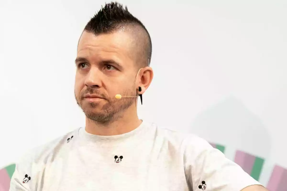 Home amb samarreta de Mickey Mouse i micròfon de diadema mirant cap a un costat Home amb samarreta de Mickey Mouse i micròfon de diadema mirant cap a un costat