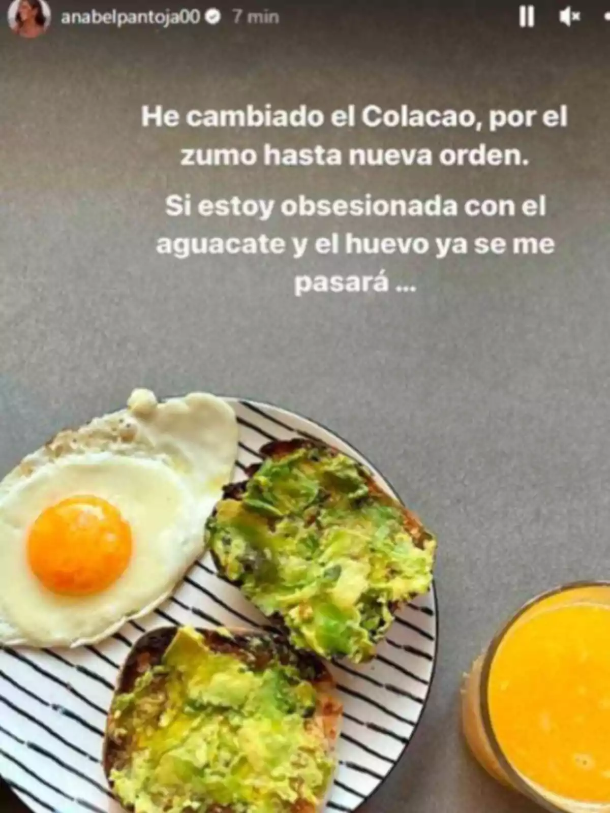 Esmorzar amb ou ferrat, pa amb alvocat i un got de suc de taronja sobre una taula grisa Esmorzar amb ou ferrat, pa amb alvocat i un got de suc de taronja sobre una taula grisa