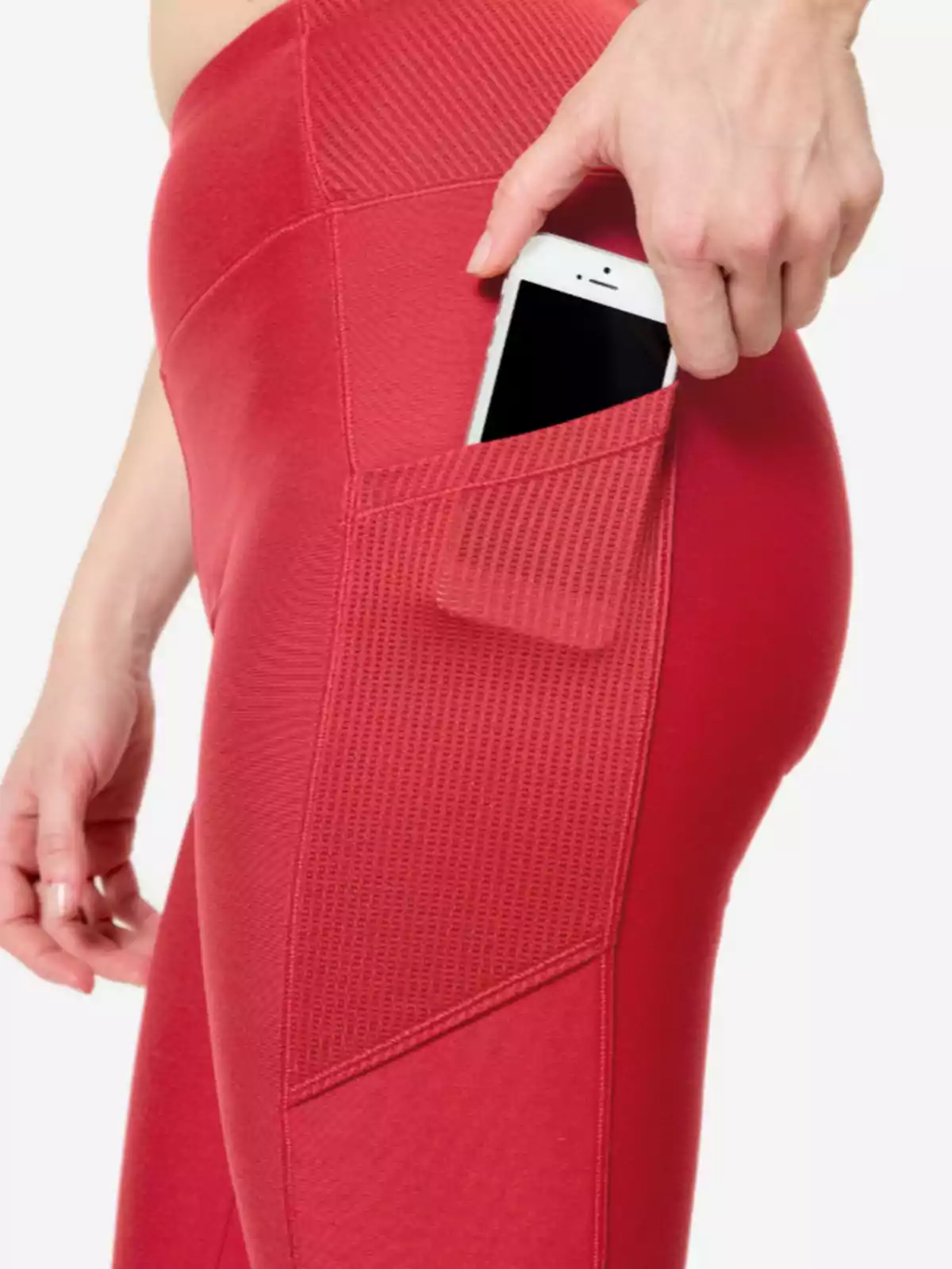 Persona guardant un telèfon mòbil a la butxaca lateral d’uns leggings esportius vermells