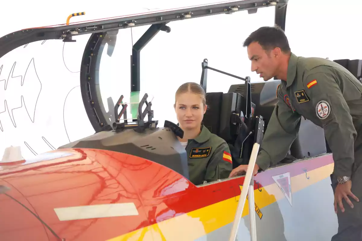 La princesa Leonor vestida amb uniforme militar està asseguda a la cabina d’un avió mentre un home, també amb uniforme, li dona indicacions. La princesa Leonor vestida amb uniforme militar està asseguda a la cabina d’un avió mentre un home, també amb uniforme, li dona indicacions.