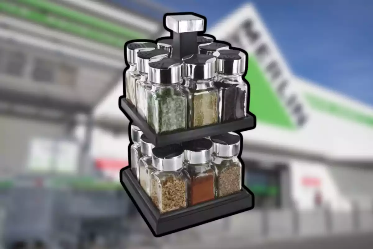 Un especier giratori de dos nivells amb pots de vidre i tapes platejades, al fons s’observa la façana d’una botiga.