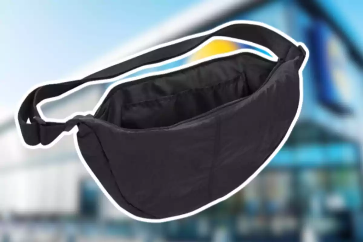 Bossa tipus ronyonera negra amb corretja ajustable sobre un fons desenfocat d’una botiga