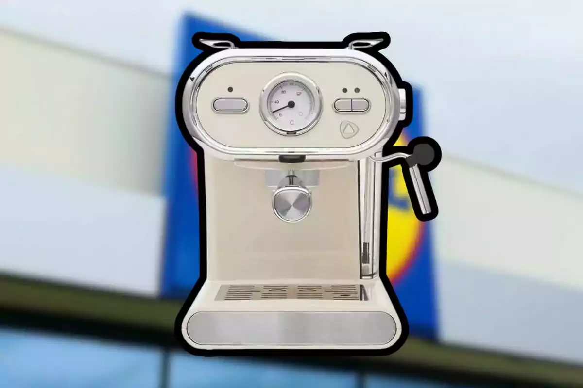 Cafetera de color crema amb detalls platejats sobre un fons desenfocat d’una botiga Cafetera de color crema amb detalls platejats sobre un fons desenfocat d’una botiga