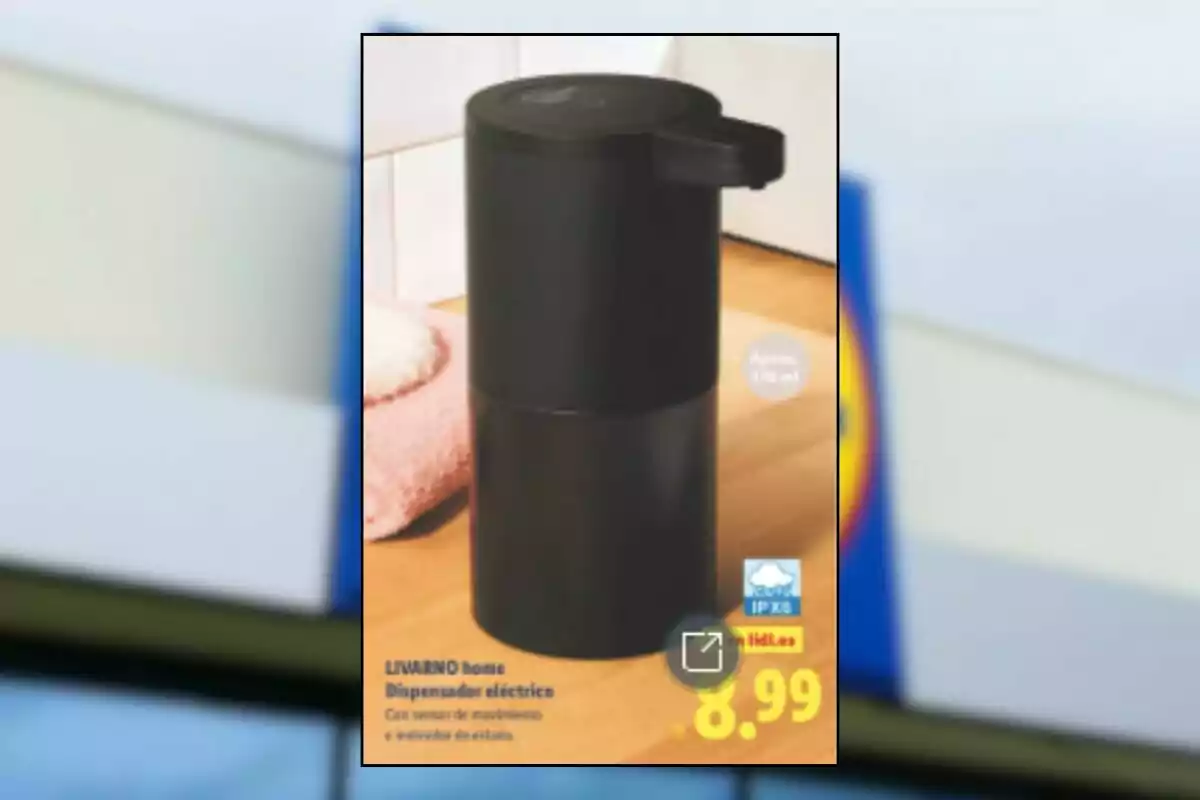 Dispositiu dispensador elèctric negre sobre una taula de fusta al costat d’una tovallola rosa amb un preu de 8,99 euros.