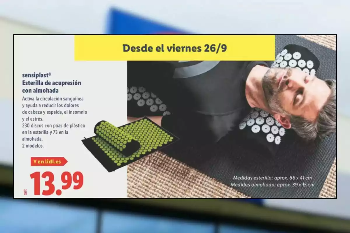 Home estirat utilitzant una estoreta d’acupressió amb coixí de color negre amb discos blancs, al costat d’una imatge del producte enrotllat i el preu de 13,99 euros en una promoció de Lidl disponible des de divendres 26 de setembre.