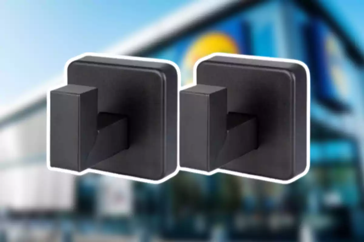 Dos ganxos negres de paret amb un fons desenfocat d’un edifici modern