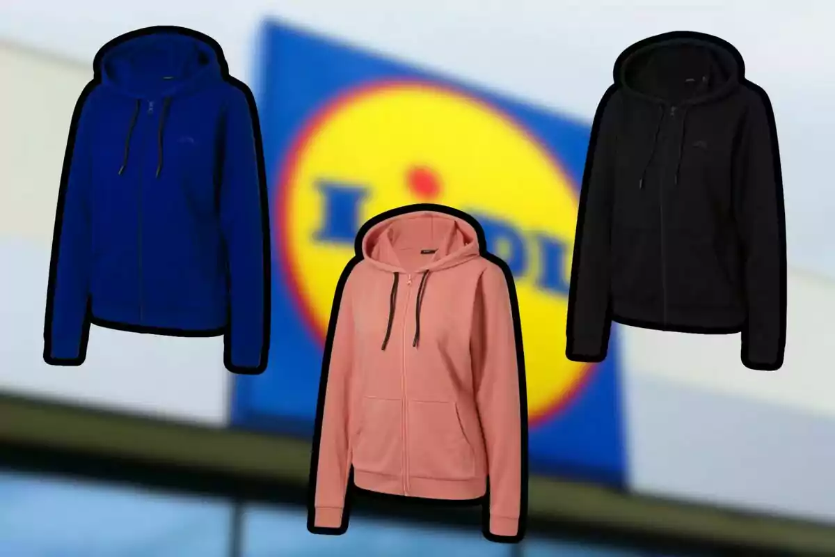 Tres dessuadores amb caputxa de color blau, rosa i negre davant d’un cartell borros de la botiga Lidl
