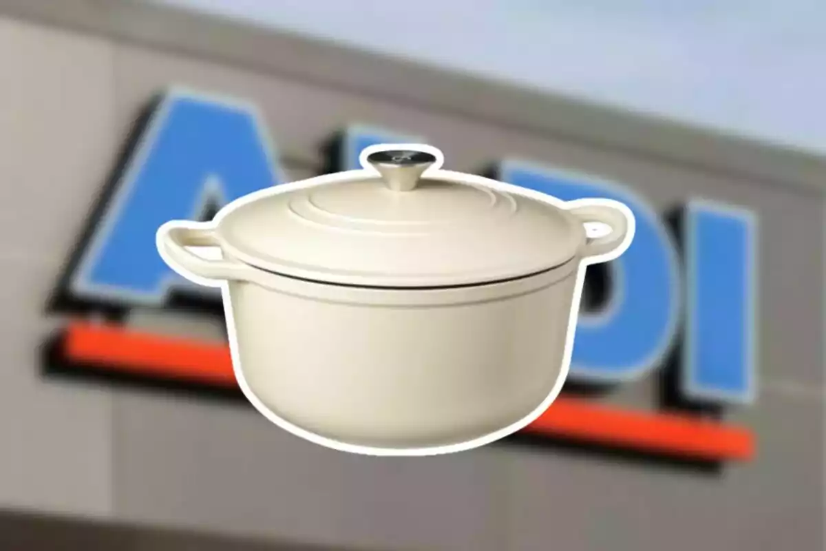 Cream-colored pot with lid and handles in front of a blurry store sign Cream-colored pot with lid and handles in front of a blurry store sign