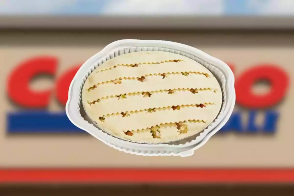 Raw chicken pot pie in an aluminum container in front of a blurry Costco sign