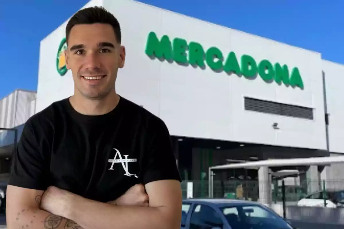 Hombre joven sonriendo con los brazos cruzados frente a un supermercado Mercadona Hombre joven sonriendo con los brazos cruzados frente a un supermercado Mercadona