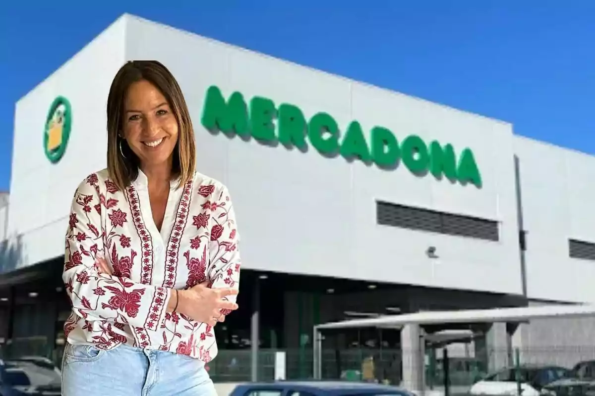 Mujer sonriente con blusa blanca y roja de pie frente a un supermercado Mercadona