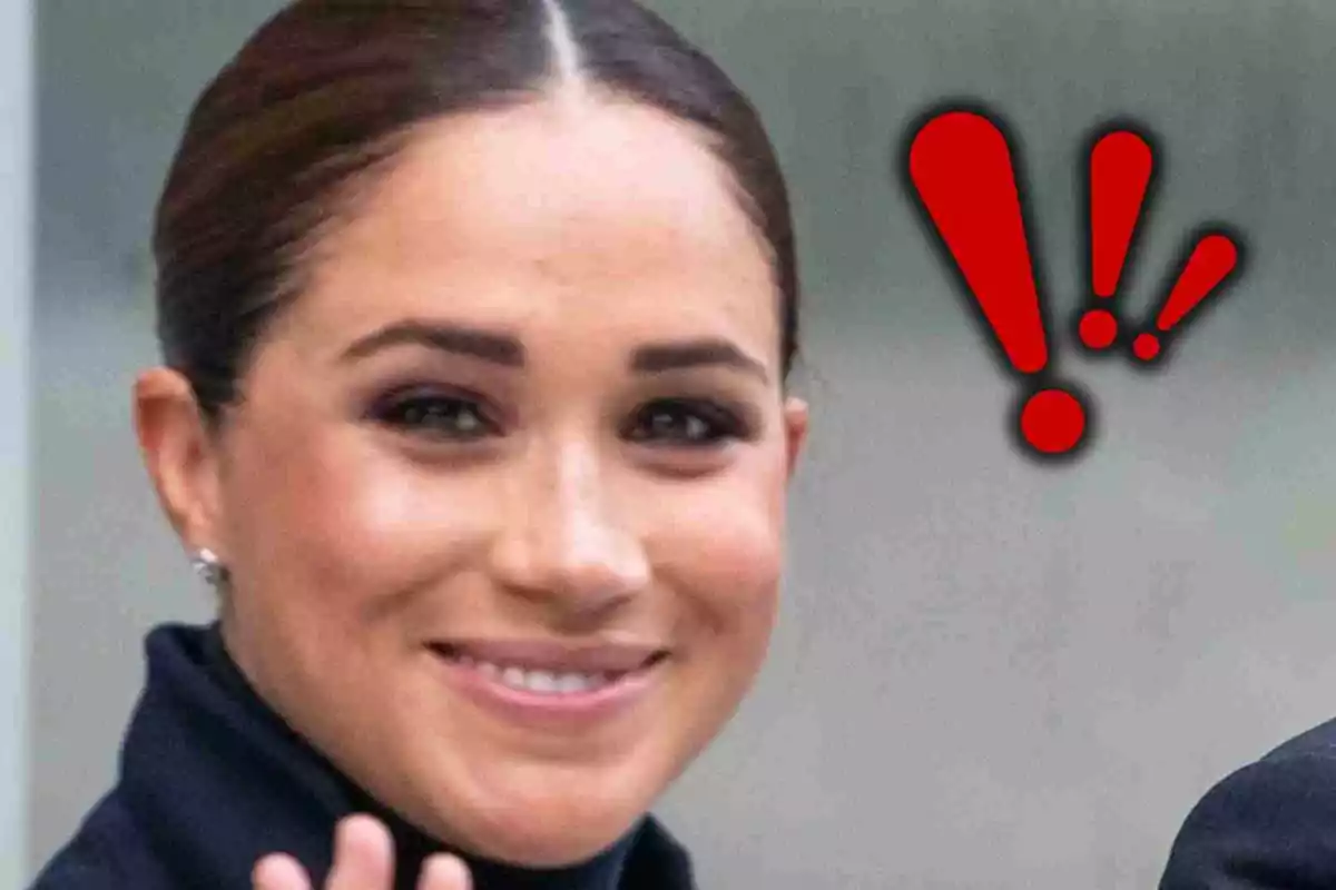 Meghan Markle somrient i saludant amb signes d’exclamació vermells al fons Meghan Markle somrient i saludant amb signes d’exclamació vermells al fons