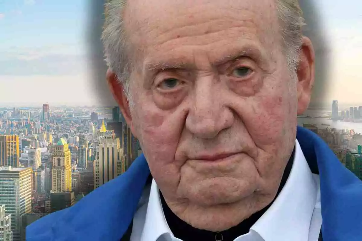 Primer pla del rei Joan Carles I amb expressió seriosa i de fons Nova York amb gratacels