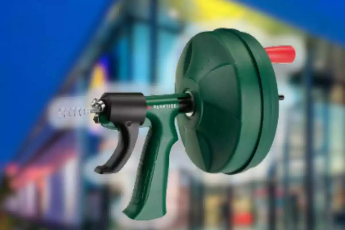 Herramienta destapacaños manual de color verde y negro con fondo desenfocado de edificio moderno