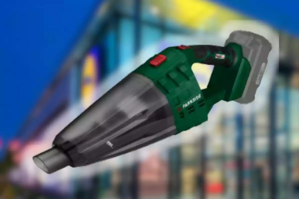 Aspiradora de mà sense fils de color verd i negre sobre un fons borros d’edifici modern Aspiradora de mà sense fils de color verd i negre sobre un fons borros d’edifici modern