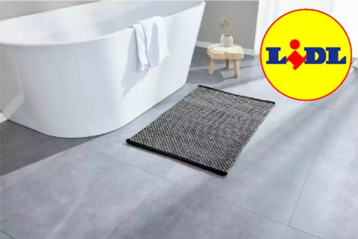 Catifa de bany grisa sobre un terra de rajoles al costat d’una banyera blanca i el logotip de Lidl a la cantonada superior dreta