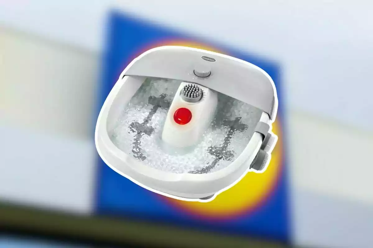 Banyera d’hidromassatge per a peus de color blanc i gris amb bombolles i un fons desenfocat de colors blau, groc i blanc Banyera d’hidromassatge per a peus de color blanc i gris amb bombolles i un fons desenfocat de colors blau, groc i blanc