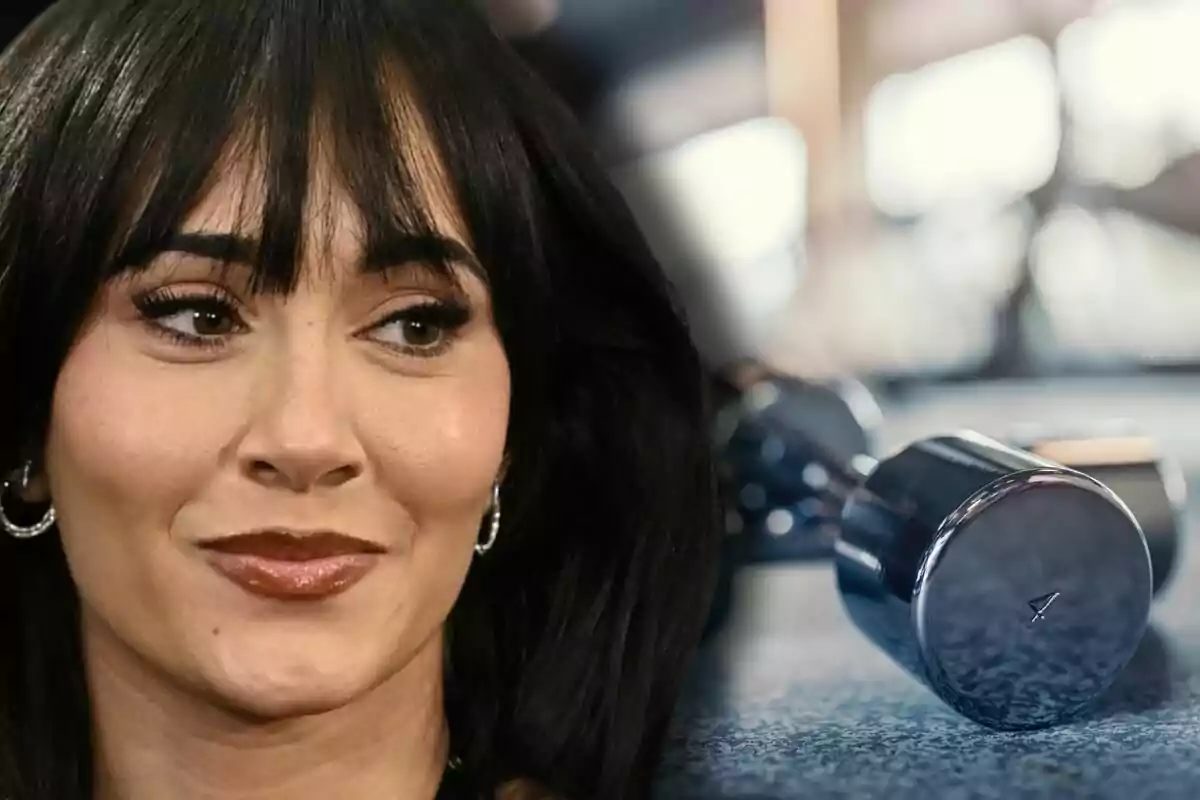 Aitana con expresión pensativa al lado de una pesa metálica en un gimnasio desenfocado Aitana con expresión pensativa al lado de una pesa metálica en un gimnasio desenfocado