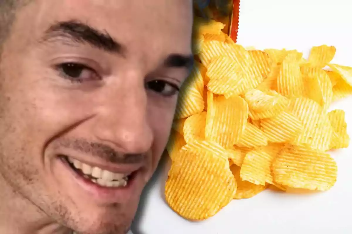 Un hombre sonriente aparece junto a un montón de papas fritas onduladas sobre una superficie blanca