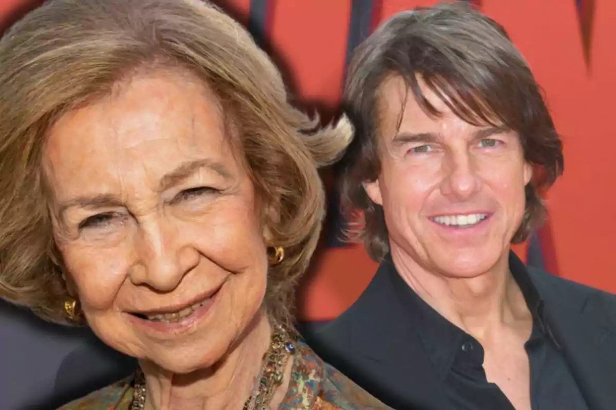 La reina Sofía sonriente en primer plano y Tom Cruise sonriente en el fondo sobre un fondo rojo