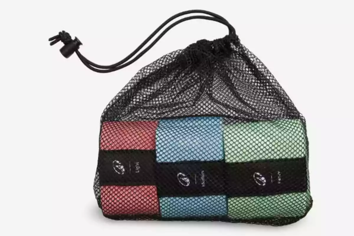 Bossa de xarxa negra amb tancament de cordó que conté sis tovalloles enrotllades de color vermell, blau i verd