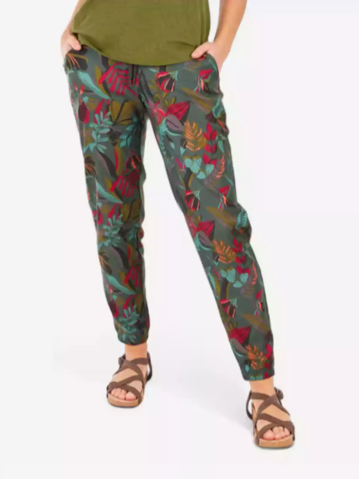 Persona vestint pantalons amb estampat de fulles de colors i sandàlies marrons Persona vestint pantalons amb estampat de fulles de colors i sandàlies marrons
