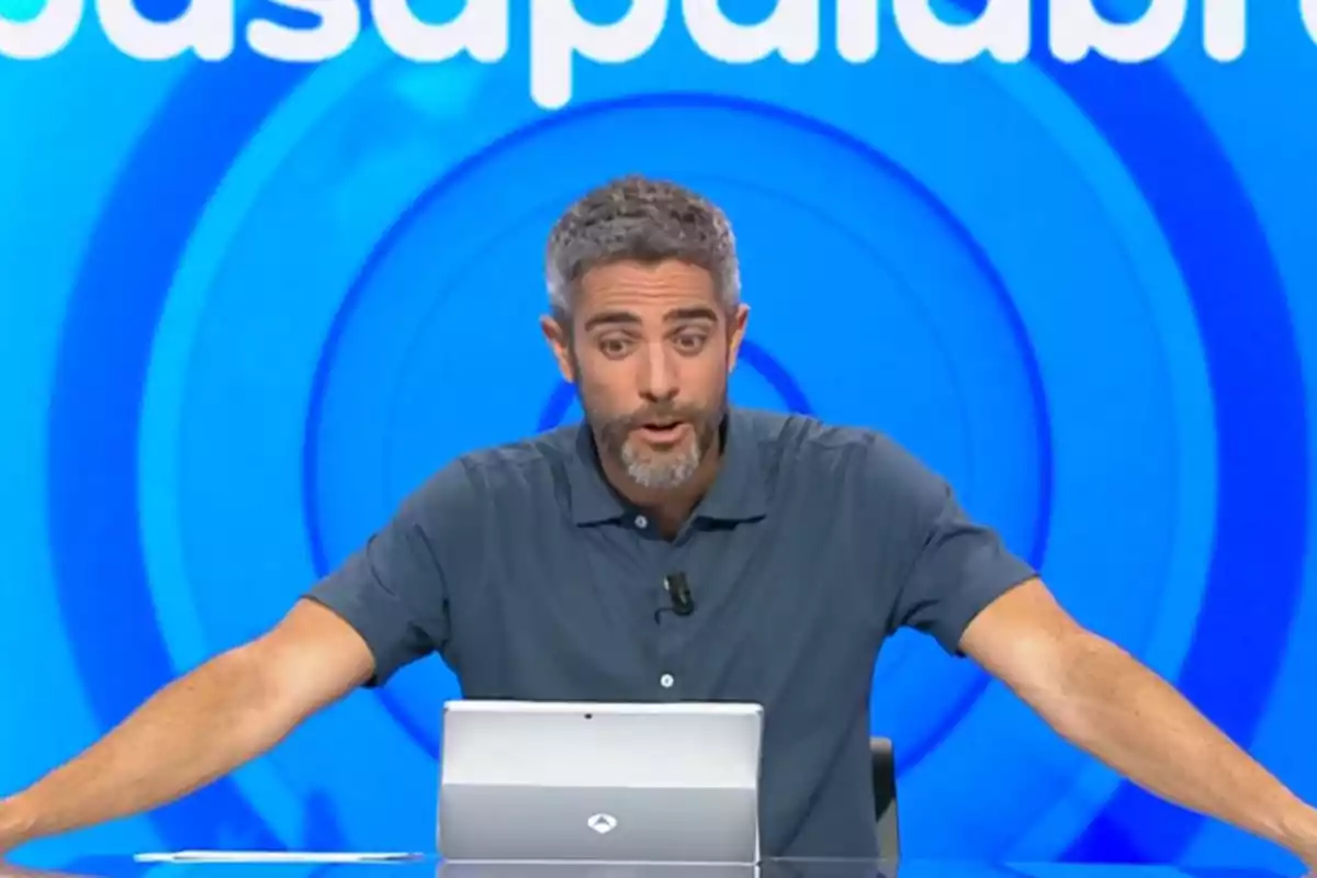 Roberto Leal assegut davant d’una tauleta en un plató de televisió amb fons blau i lletres blanques. Captura de ‘Pasapalabra’. Roberto Leal assegut davant d’una tauleta en un plató de televisió amb fons blau i lletres blanques. Captura de ‘Pasapalabra’.