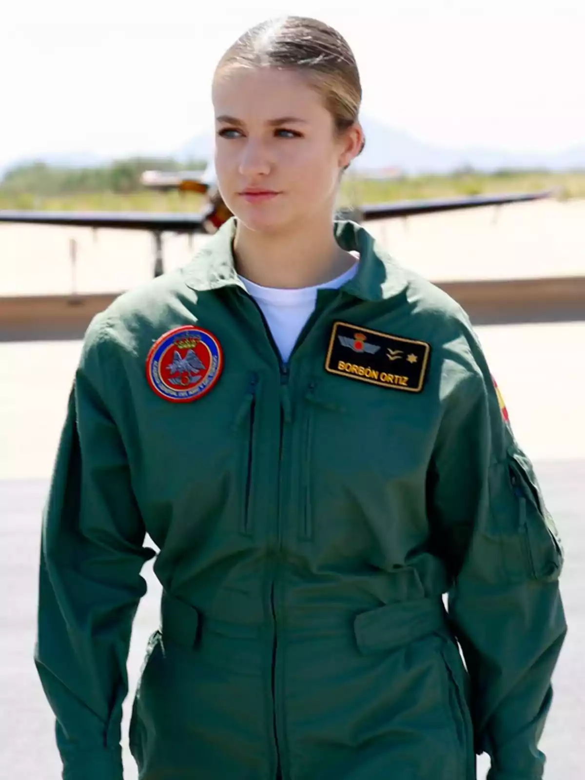 La princesa Leonor vestida amb uniforme de pilot militar verd dreta a l’aire lliure amb un avió al fons La princesa Leonor vestida amb uniforme de pilot militar verd dreta a l’aire lliure amb un avió al fons