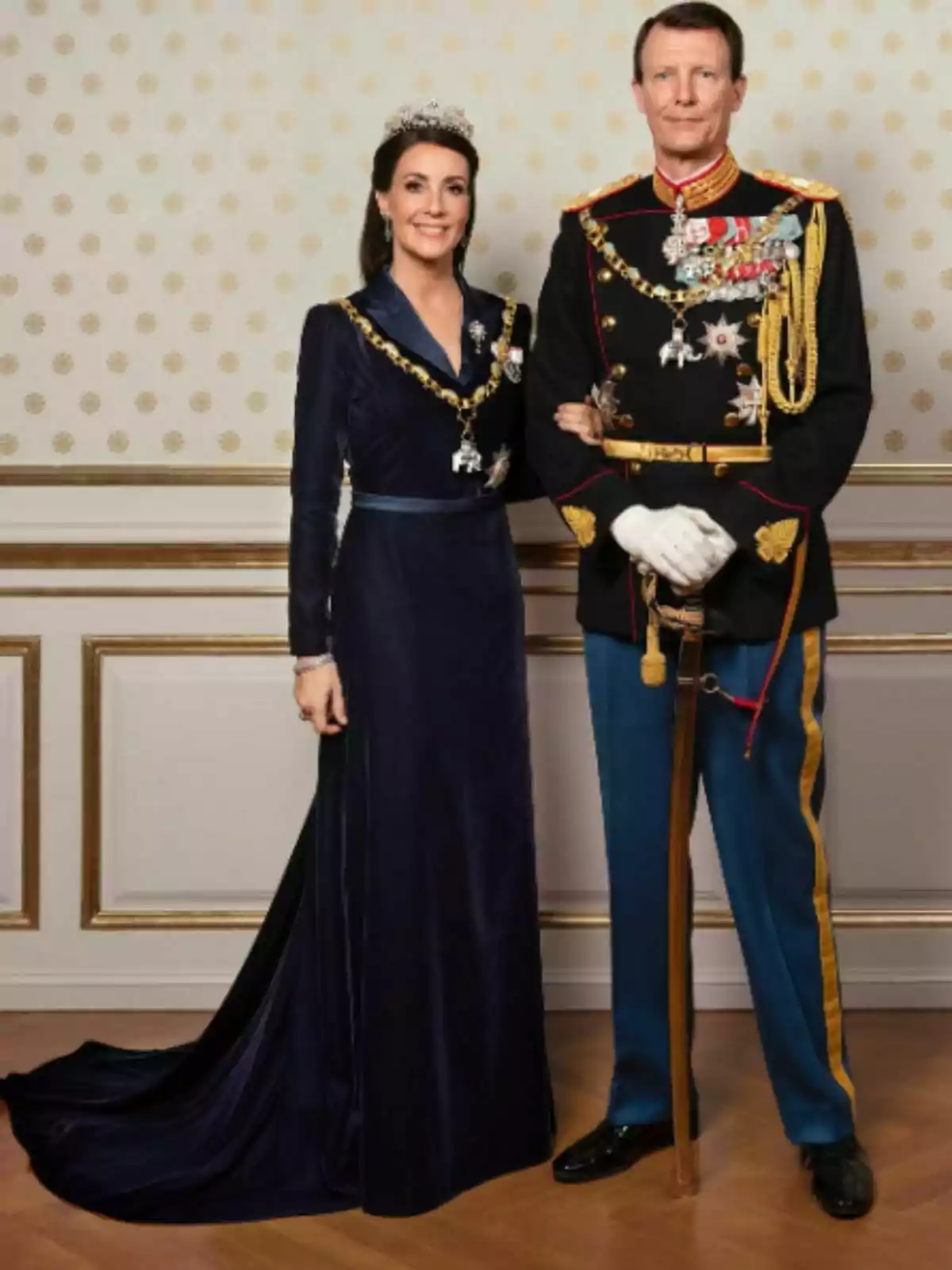 Marie i Joaquim de Dinamarca vestits amb vestits de gala i condecoracions posant en un saló elegant