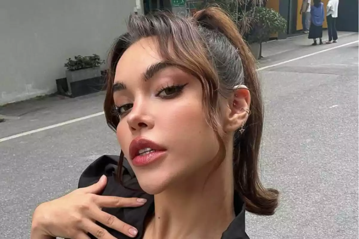 Dona jove amb maquillatge i pentinat elegant fent-se una selfie al carrer