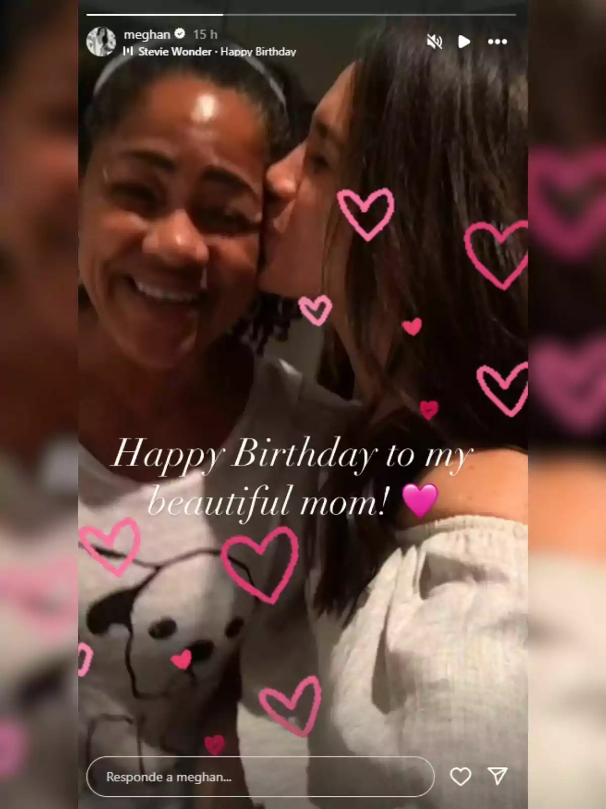 Doria y Meghan Markle sonríen mientras una besa a la otra en la mejilla, rodeadas de dibujos de corazones rosas y un mensaje de feliz cumpleaños para la mamá
