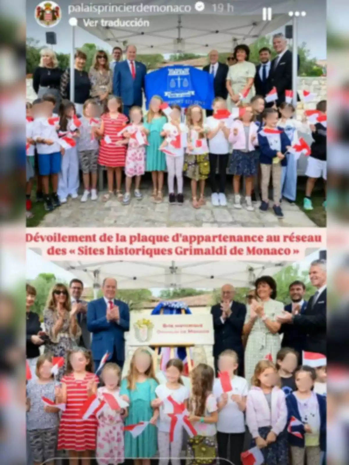 Un grup d’adults i nens posen junts a l’aire lliure en un esdeveniment oficial, alguns sostenen banderes i una placa commemorativa, tots sota una carpa blanca.