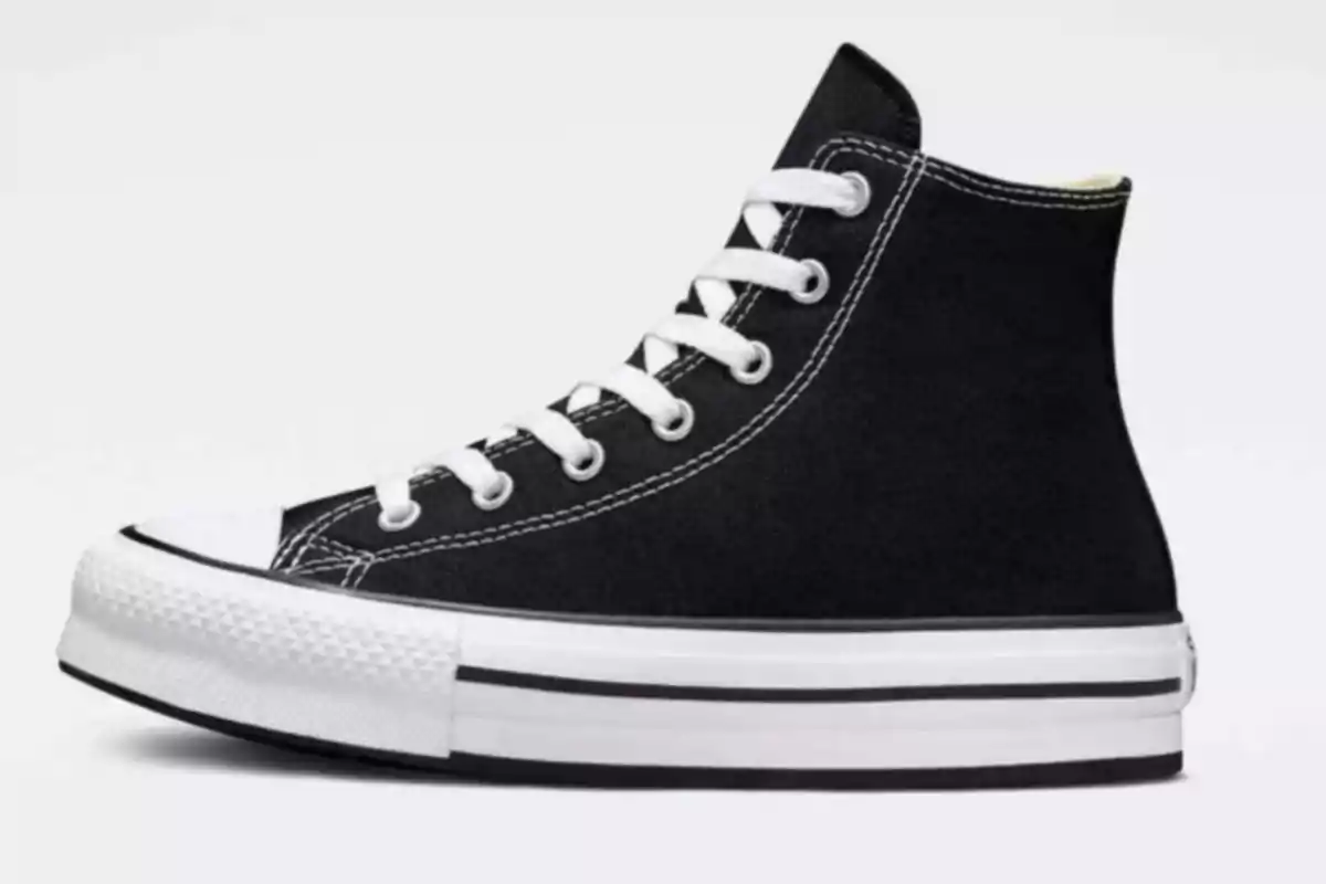 Sabata esportiva negra de lona tipus bota amb sola blanca i detalls en blanc