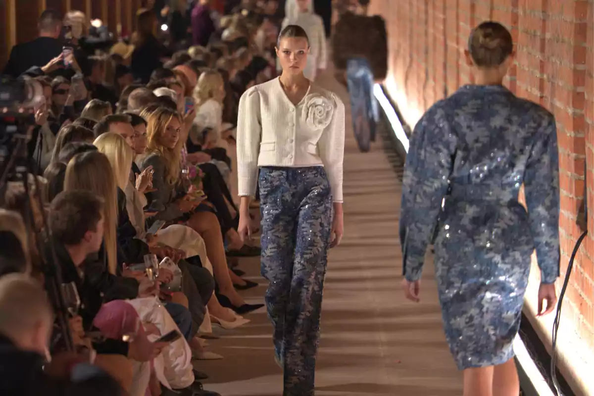 Desfile de moda con modelos caminando por la pasarela y público observando atentamente Desfile de moda con modelos caminando por la pasarela y público observando atentamente